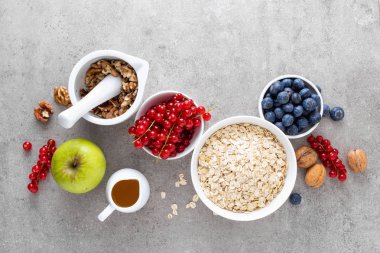 Taze çilek, yaban mersini, frenk üzümü, ceviz ve ballı yulaf ezmesi yemek. Sağlıklı vejetaryen kahvaltı gıda kavramı, üstten görünüm, düz yatıyordu