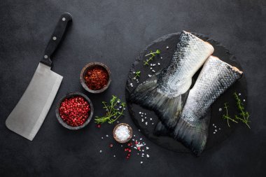 Siyah arka plan üzerinde yemek pişirmek için malzemelerle çiğ somon fishtails, üst görünümü