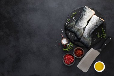 Siyah arka plan üzerinde yemek pişirmek için malzemelerle çiğ somon fishtails, üst görünümü