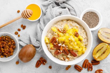 Kahvaltıda kivi meyve, pekan fıstığı ve bal ile yulaf ezmesi lapası