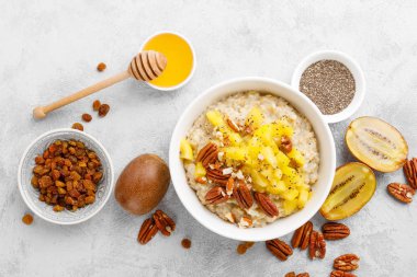 Kahvaltıda kivi meyve, pekan fıstığı ve bal ile yulaf ezmesi lapası