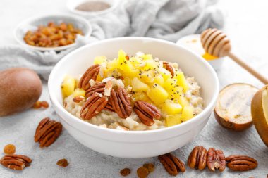 Kahvaltıda kivi meyve, pekan fıstığı ve bal ile yulaf ezmesi lapası