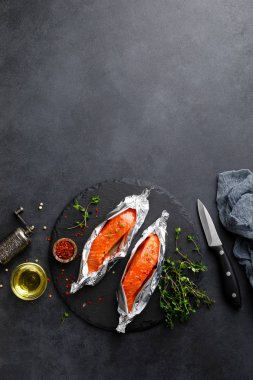 Siyah arka plan üzerinde folyo çiğ somon balık fileto