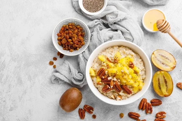 Kahvaltıda kivi meyve, pekan fıstığı ve bal ile yulaf ezmesi lapası