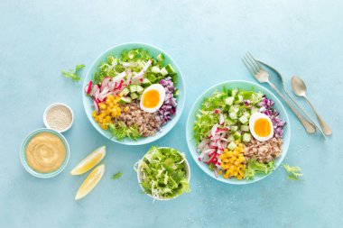 Haşlanmış yumurta, pirinç ve taze marul, turp, salatalık, mısır, soğan ve susam ve nohut sos sebze salatası ile Buda kase