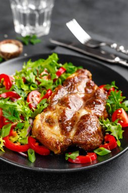 Bir tabakta taze sebze salatası ile Pişmiş domuz biftek