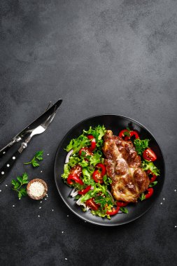 Bir tabakta taze sebze salatası ile Pişmiş domuz biftek