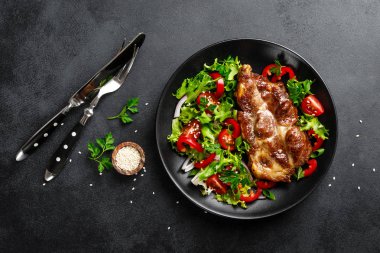 Bir tabakta taze sebze salatası ile Pişmiş domuz biftek