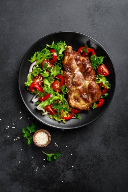 Bir tabakta taze sebze salatası ile Pişmiş domuz biftek