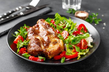 Bir tabakta taze sebze salatası ile Pişmiş domuz biftek