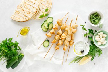 Şişler ve geleneksel Yunan tzatziki yoğurt sosu üzerinde ızgara tavuk kebap, yukarıdan tview