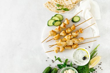 Şişler ve geleneksel Yunan tzatziki yoğurt sosu üzerinde ızgara tavuk kebap, yukarıdan tview