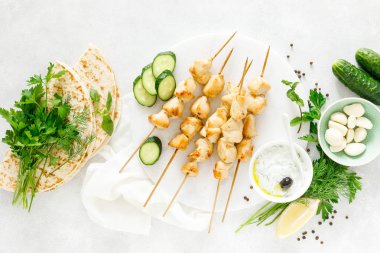 Şişler ve geleneksel Yunan tzatziki yoğurt sosu üzerinde ızgara tavuk kebap, yukarıdan tview