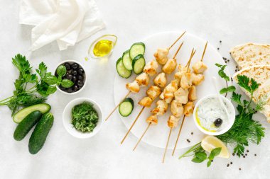 Şişler ve geleneksel Yunan tzatziki yoğurt sosu üzerinde ızgara tavuk kebap, yukarıdan tview