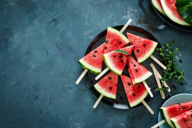 Mavi arka planda karpuz dilim Popsicles, üst görünüm