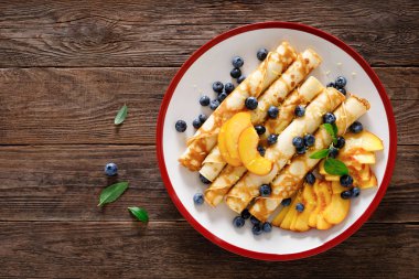 Tatlı krep taze yaban mersini ve şeftali ile dolu