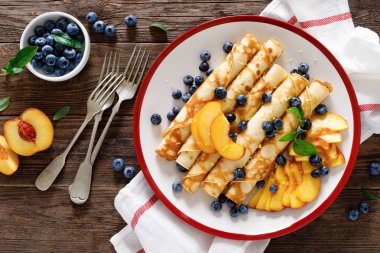 Tatlı krep taze yaban mersini ve şeftali ile dolu