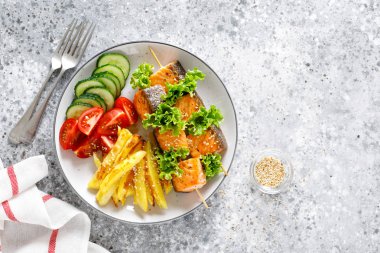 Fırında patates, taze salatalık ve domates ile şiş üzerinde ızgara somon kebap