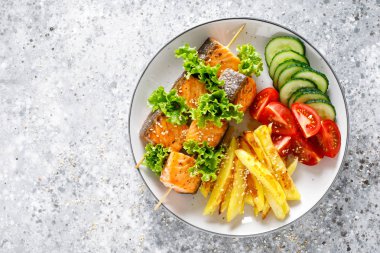 Fırında patates, taze salatalık ve domates ile şiş üzerinde ızgara somon kebap