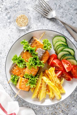 Fırında patates, taze salatalık ve domates ile şiş üzerinde ızgara somon kebap