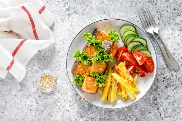 Fırında patates, taze salatalık ve domates ile şiş üzerinde ızgara somon kebap