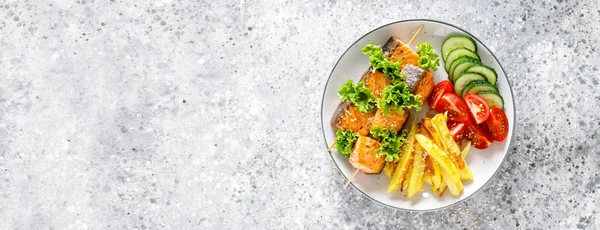 Fırında patates, taze salatalık ve domates ile şiş üzerinde ızgara somon kebap. Afiş