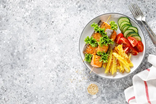 Fırında patates, taze salatalık ve domates ile şiş üzerinde ızgara somon kebap