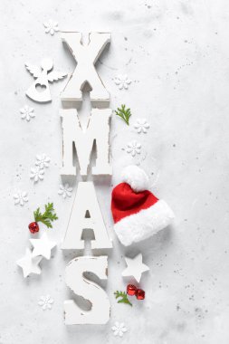 Noel, Yeni Yıl veya Noel bayramı bayramı kutlama kartı süslemeleri, X-mas süsleri, yıldızlar, kar taneleri, Noel Baba şapkası ve Noel çanları beyaz arka planda, düz konum, üst görünüm, kopyalama alanı