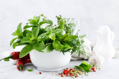 Mutfak masasındaki havanda bir demet aromatik ot.