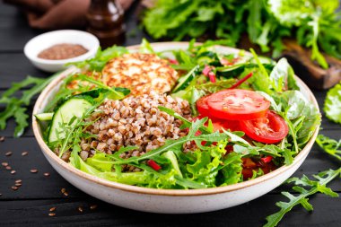 Karabuğday lapası, kızarmış tavuk pirzolası ve taze roka salatası, marul, meyve yaprağı, domates, salatalık ve keten tohumu.