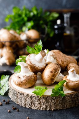 Siyah arka planda çiğ mantar şampiyonları taze şampiyon pişiriyor.