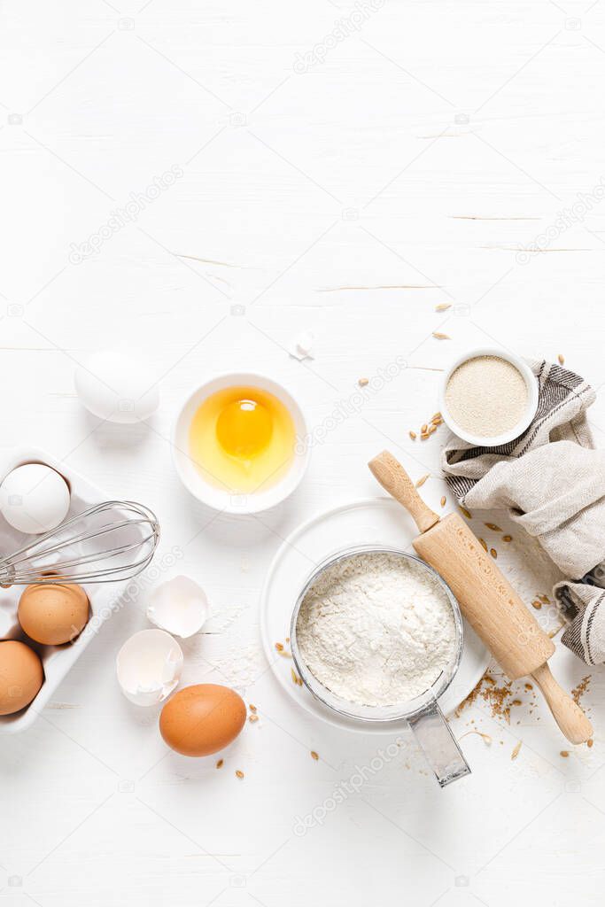 Baking homemade bread on white kitchen worktop with ingredients for cooking, culinary background, copy space, overhead view