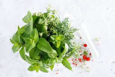 Mutfak masasındaki havanda bir demet aromatik ot.