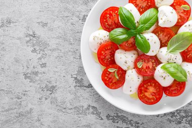 Caprese salatası. Mozzarella peynirli salata taze domates, fesleğen yaprağı ve zeytinyağı. İtalyan yemeği.