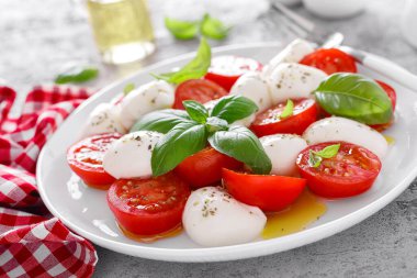 Caprese salatası. Mozzarella peynirli salata taze domates, fesleğen yaprağı ve zeytinyağı. İtalyan yemeği.