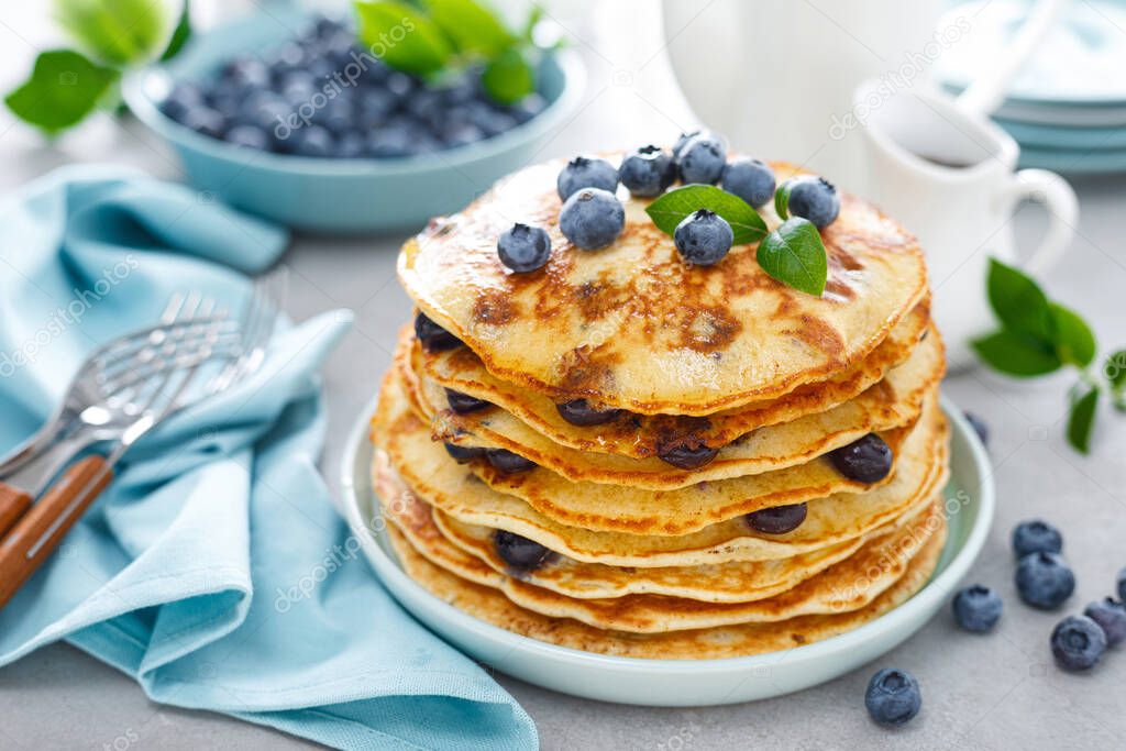 Blueberry pancakes with butter, maple syrup and fresh berries. American breakfast