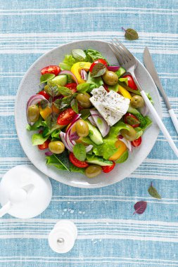 Yunan salatası. Salatalık, domates, zeytin, soğan, dolma biber, feta peyniri, marul ve ottan oluşan taze sebze salatası ve tuz, biber ve zeytinyağıyla kaplanmış. Popüler Yunan Horiatiki salatası