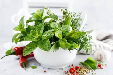 Mutfak masasındaki havanda bir demet aromatik ot.