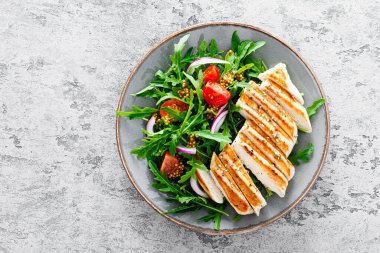 Taze sebzeli tavuk fileto salatası ve roka. Taze sebze salatası roka, domates, soğan ve ızgara tavuk göğsü..