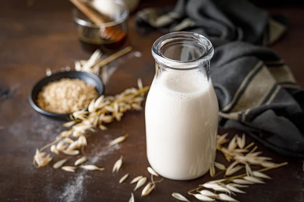 ガラス瓶の中にビーガンオートミルクと料理のための成分 健康的な菜食主義者以外の乳製品飲料または飲料 代替牛乳 — ストック写真