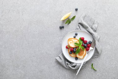 Sağlıklı vejetaryen kahvaltısı için taze yaban mersinli ve ahududulu krep.