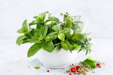 Mutfak masasındaki havanda bir demet aromatik ot.