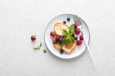 Sağlıklı vejetaryen kahvaltısı için taze yaban mersinli ve ahududulu krep.