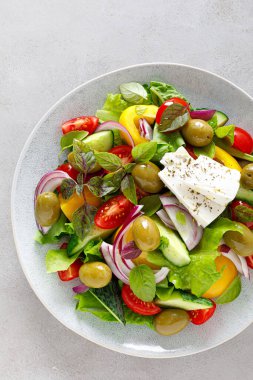 Yunan salatası. Salatalık, domates, zeytin, soğan, dolma biber, feta peyniri, marul ve ottan oluşan taze sebze salatası ve tuz, biber ve zeytinyağıyla kaplanmış. Horiatiki salatası