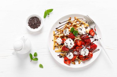 Taze çilekli Belçika waffle 'ı, çikolata soslu ve krem şantili.