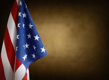 Kahverengi arka plan önünde Amerikan bayrağı.