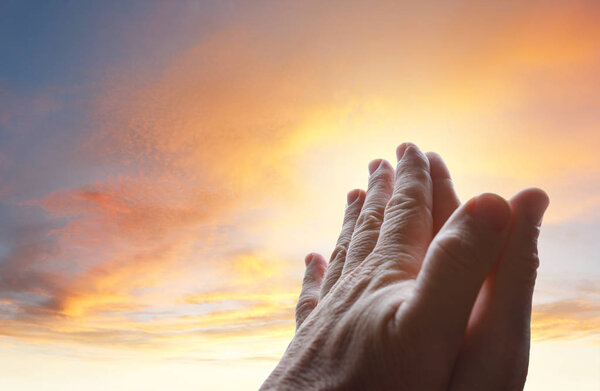 Prayer hands in sky