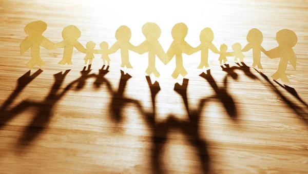 Paper chain team holding hands — Stock Photo, Image