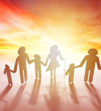 Aile kâğıdı zinciri gökyüzünün önünde el ele tutuşuyor. Parlak gelecek