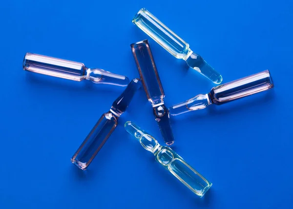 Glass Ampoules Scattered Blue Background — Stock Photo, Image